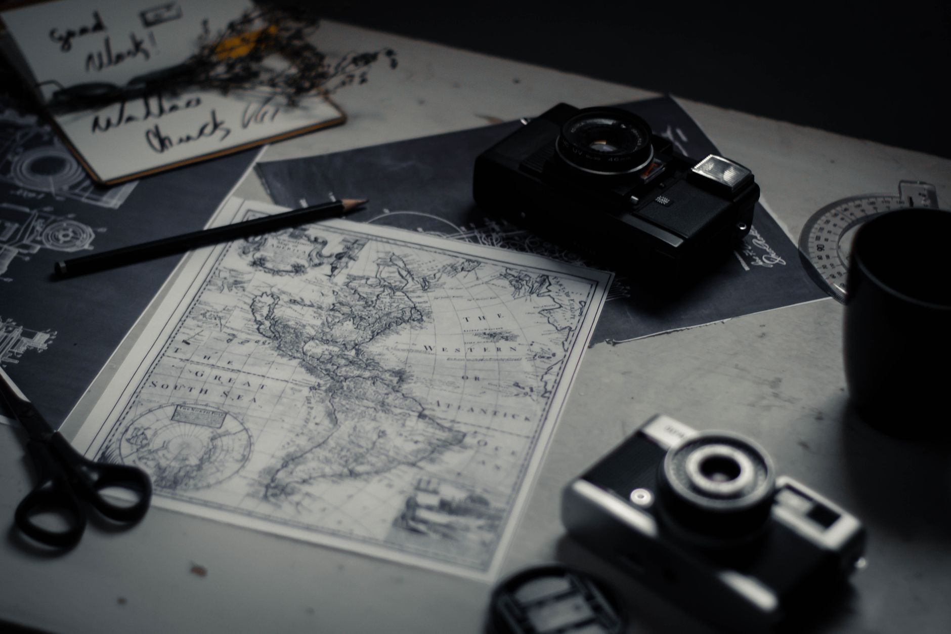 Travel journal writing desk with map and camera